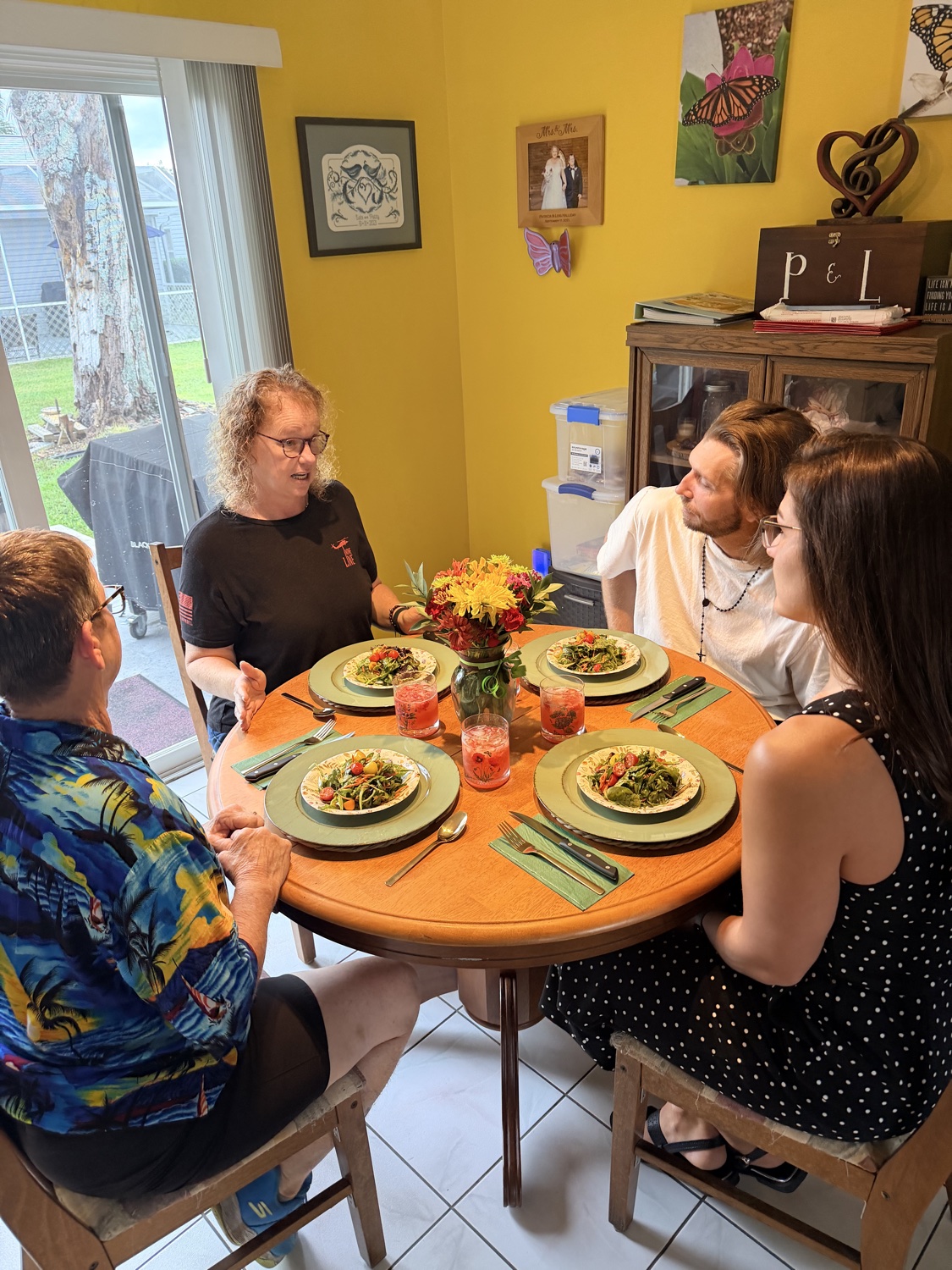 Friends sharing a salad dinner around the table at a Kombat Kitchen food gathering