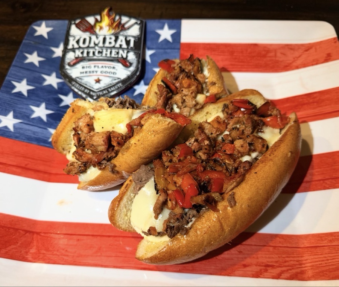 Cheesesteak sandwiches on a patriotic plate with the Kombat Kitchen sticker