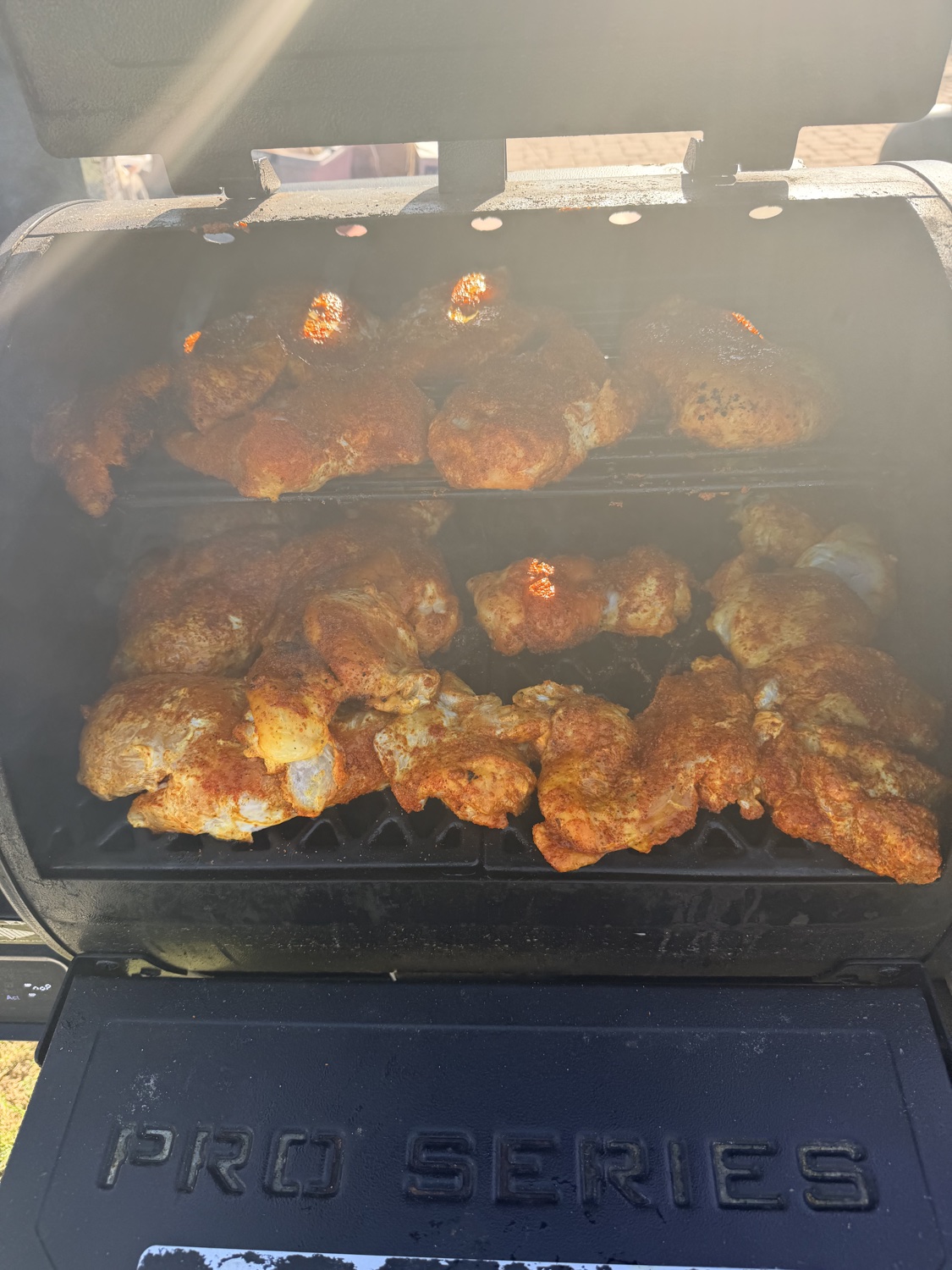 Seasoned chicken smoking on the grill