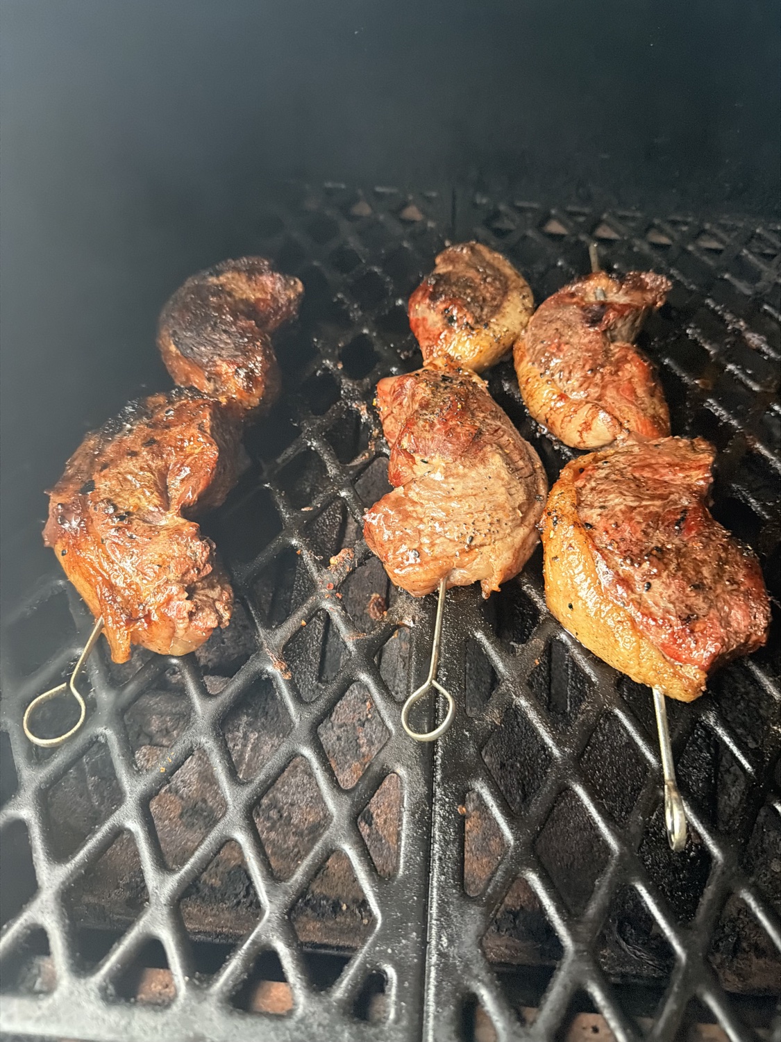 Meat skewers grilling over open flame