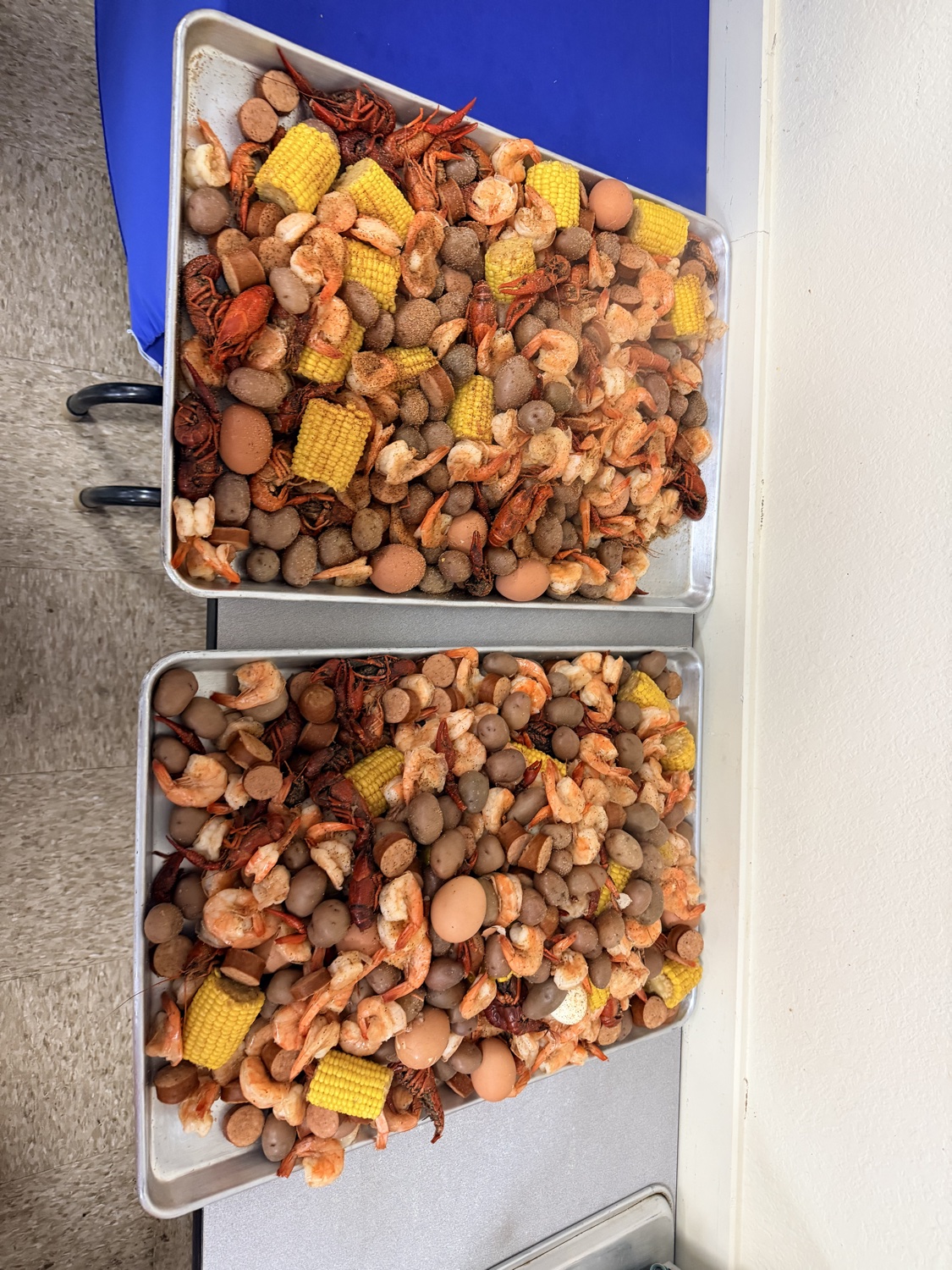 Seafood boil trays with shrimp, crawfish, corn, potatoes, and sausage