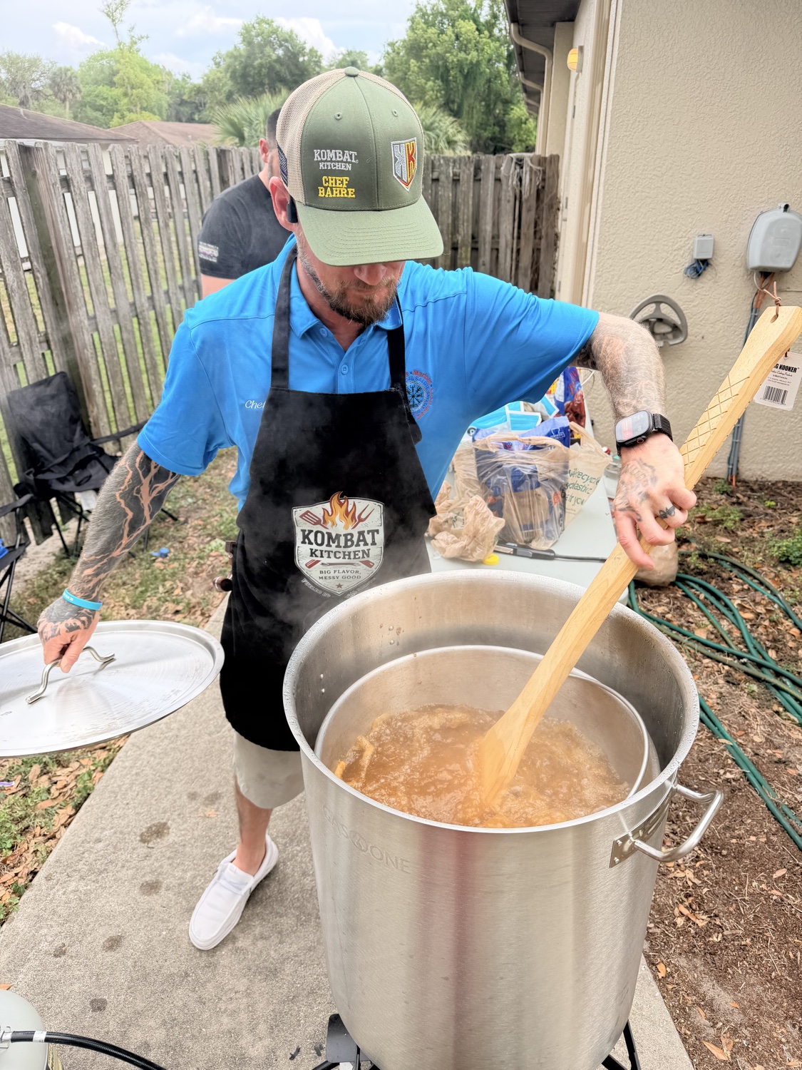Chef Bahre stirring a giant stock pot outdoors